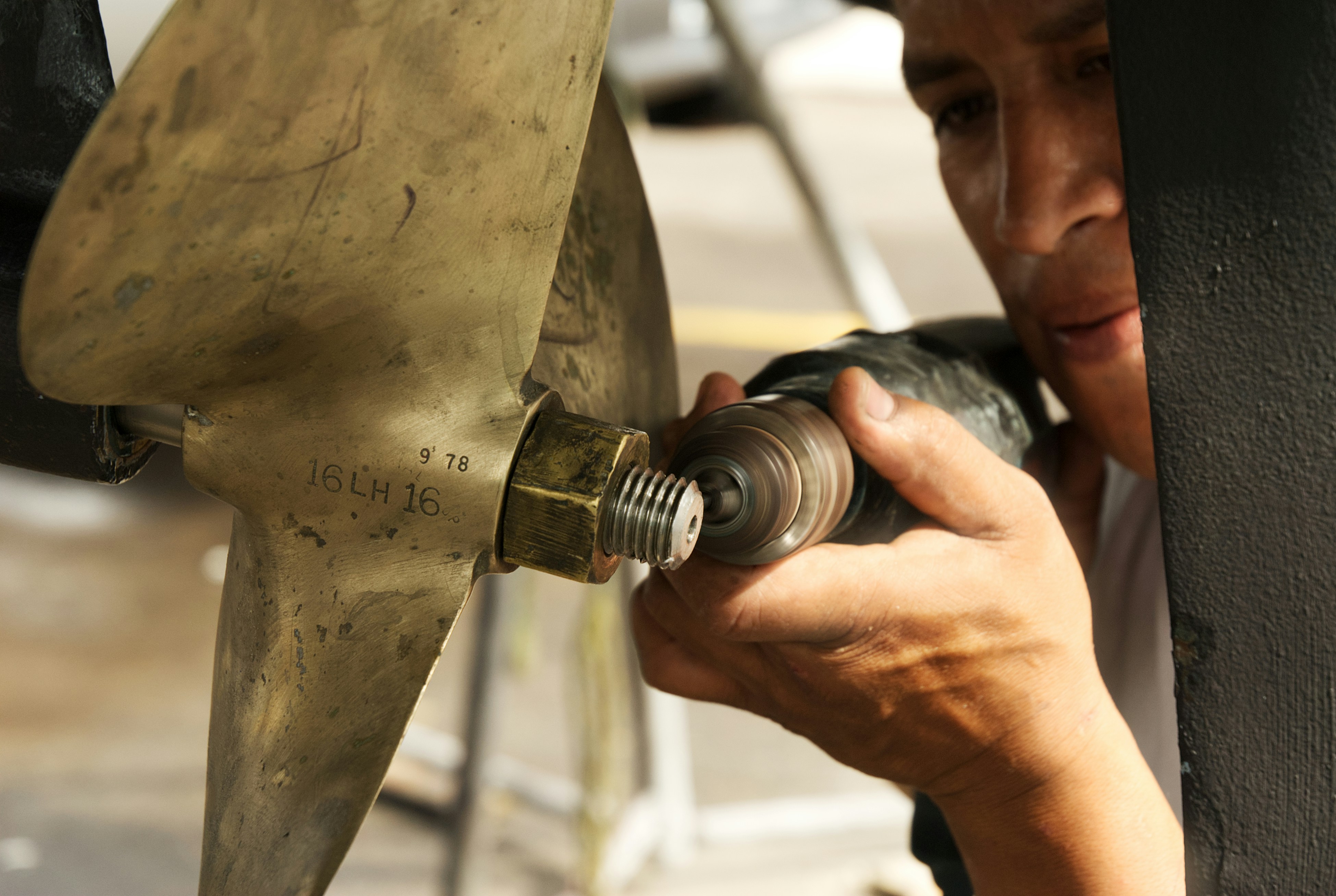 Triton Marine technician polishing a bronze propeller